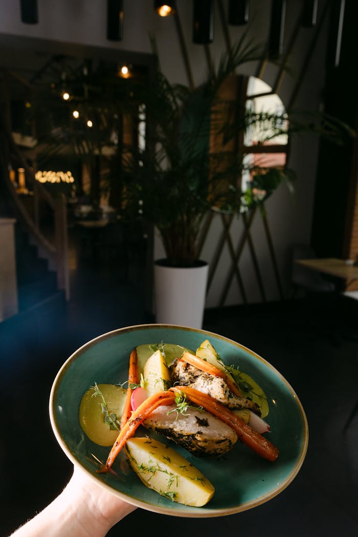 A delicious gourmet dish featuring roasted chicken and vegetables, elegantly presented indoors.